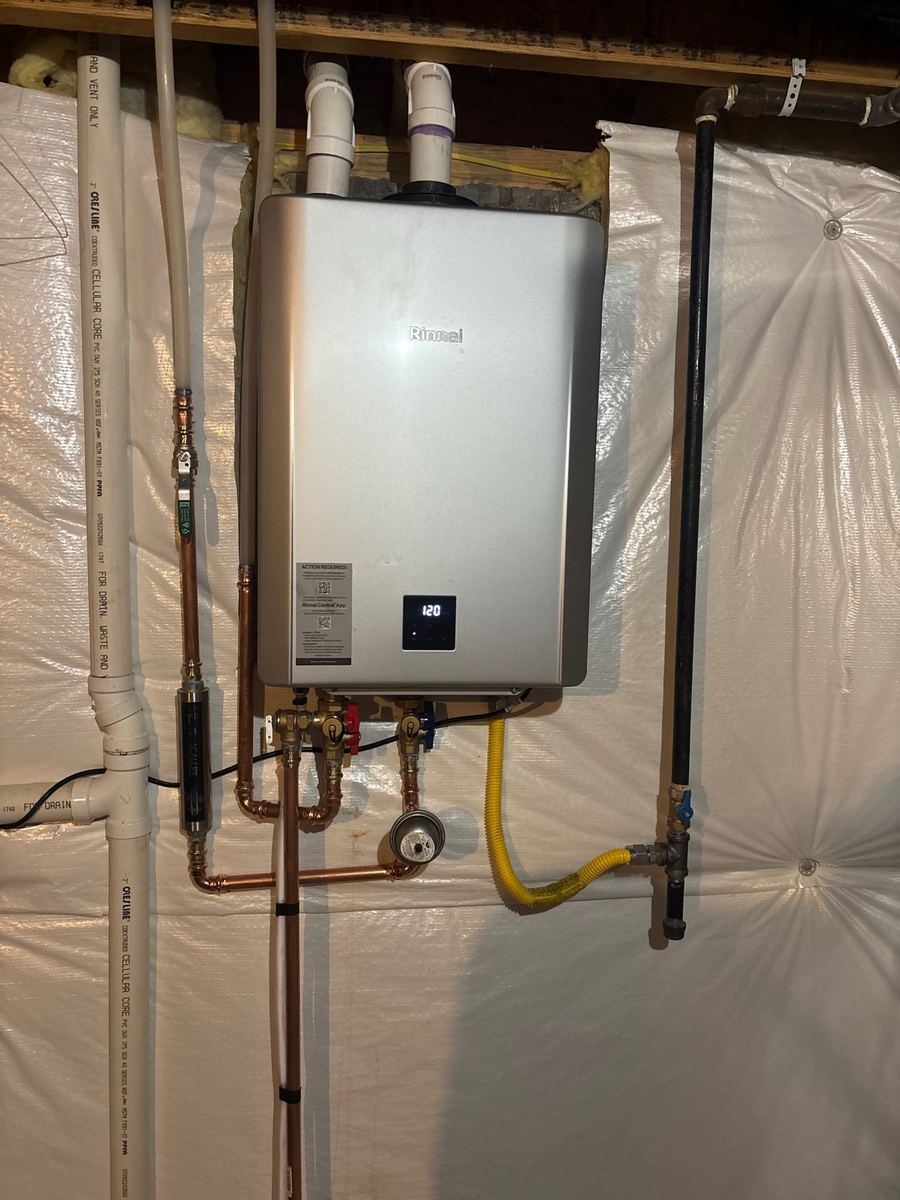 Tankless water heater unit mounted on a wall during a conversion installation in Colorado